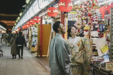 和装を着て夜の浅草商店街を楽しむ二人
