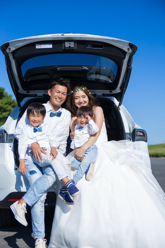 車のトランクに家族4人で座って撮ったウェディング写真