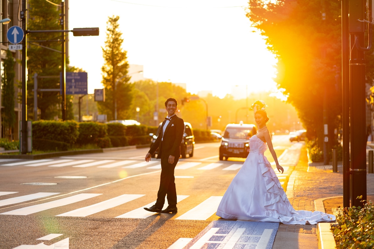 東京駅のイルミネーションの前で結婚写真を撮るカップル
