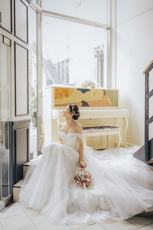 スタジオのピアノの前に座っている花嫁