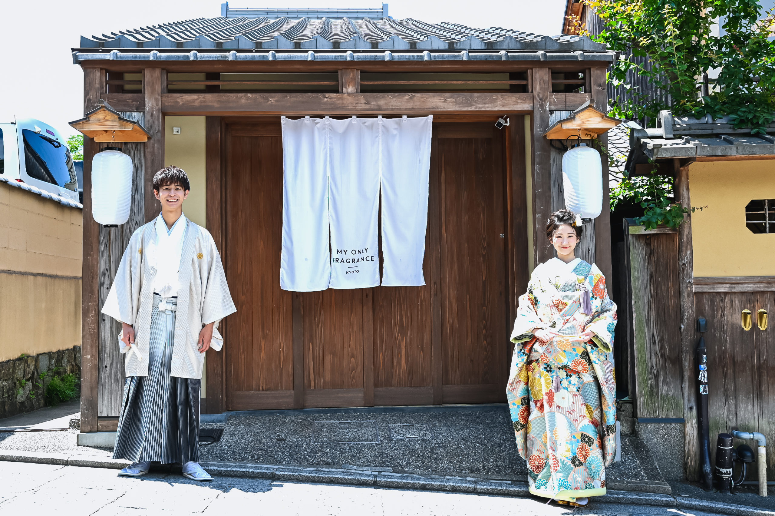 京都の老舗の前に立つ和装を着た新郎新婦