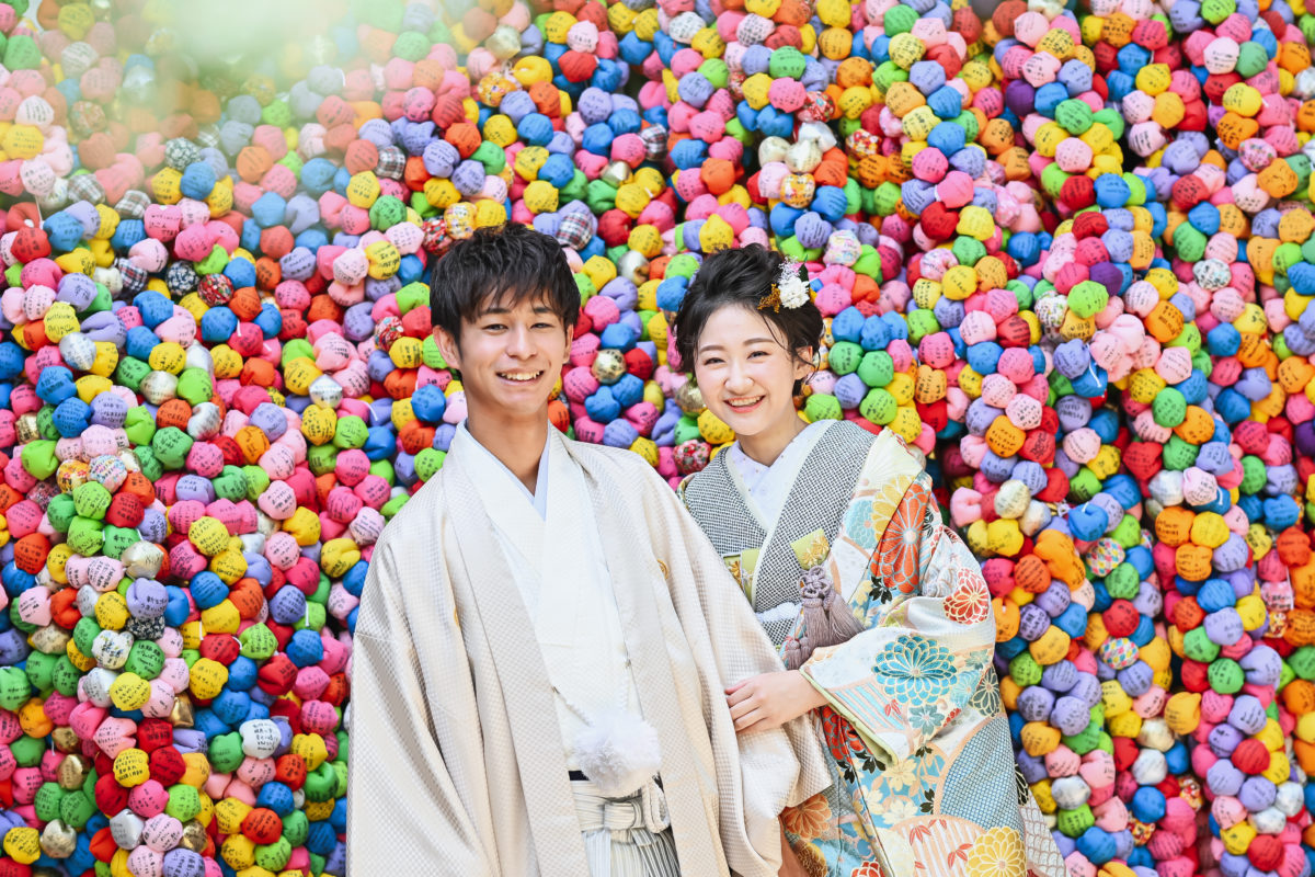 カラフルな絵馬と夫婦、前撮り撮影のワンカット