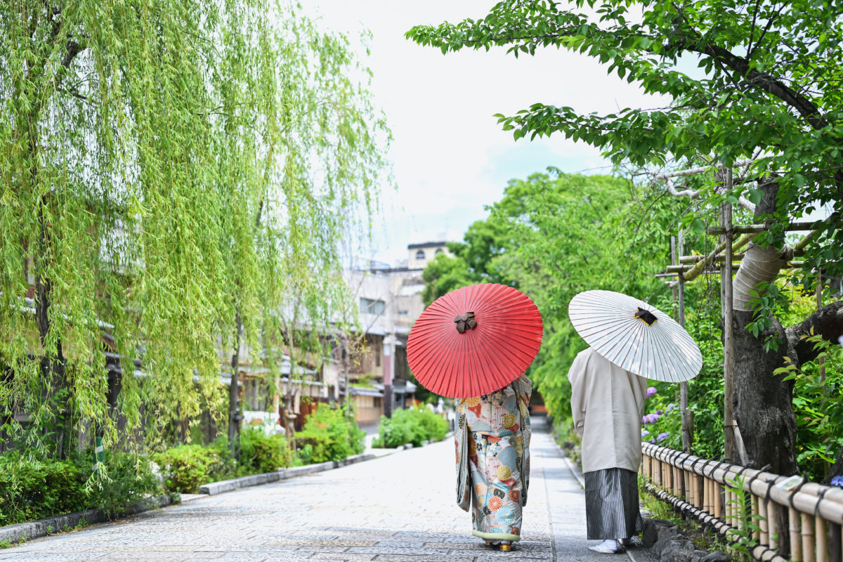 和傘を持ったふたりの後ろ姿、結婚写真として人気の一枚