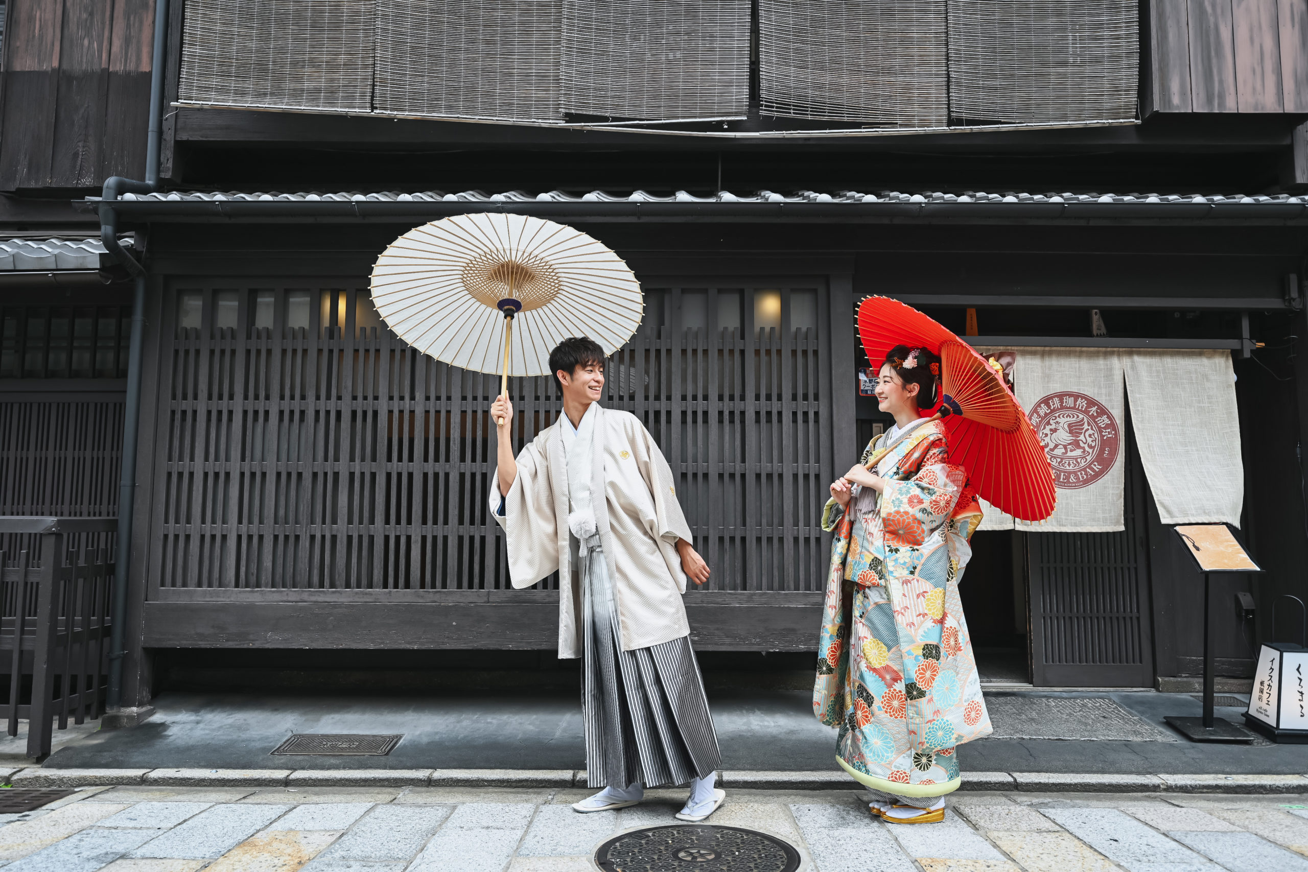 祇園の町を和傘を差して歩く夫婦