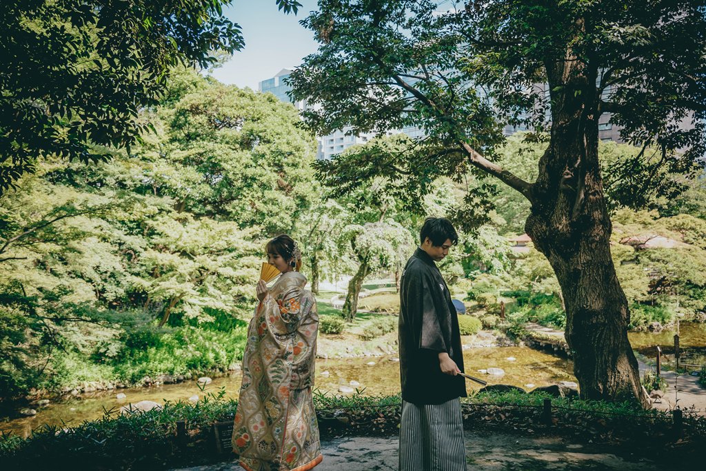 小石川後楽園の日本庭園をバックに背中で向き合ってポージング