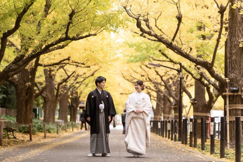 外苑前いちょう並木の黄金色の道を並んで歩く紋付袴の新郎と白無垢の花嫁。秋の和装前撮り