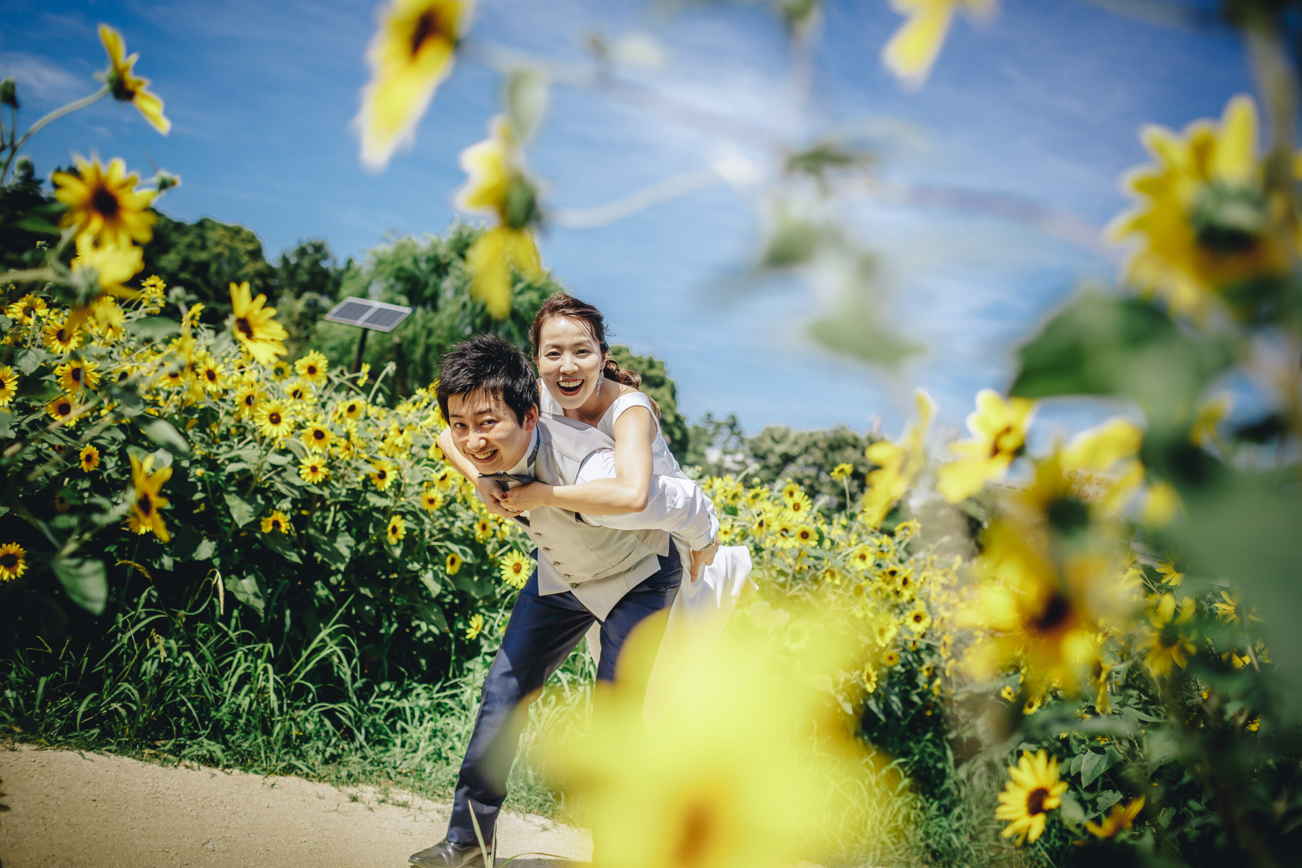 葛西臨海公園の花畑でウェディングドレスを着て笑顔のカップル