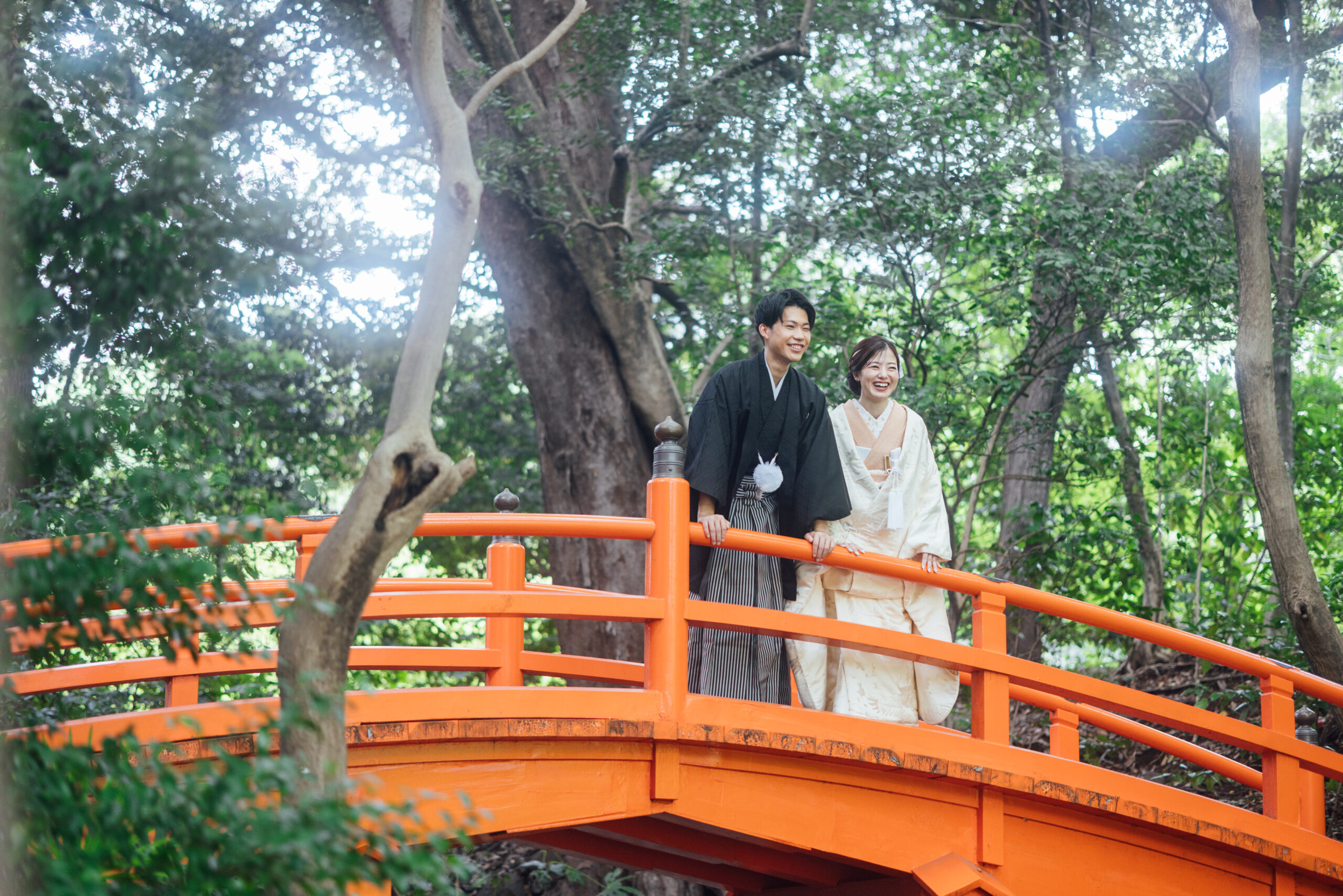 小石川後楽園の赤い通天橋での和装前撮り実例、朱色の橋と紅葉を背景に色打掛が際立つ圧倒的な存在感の一枚