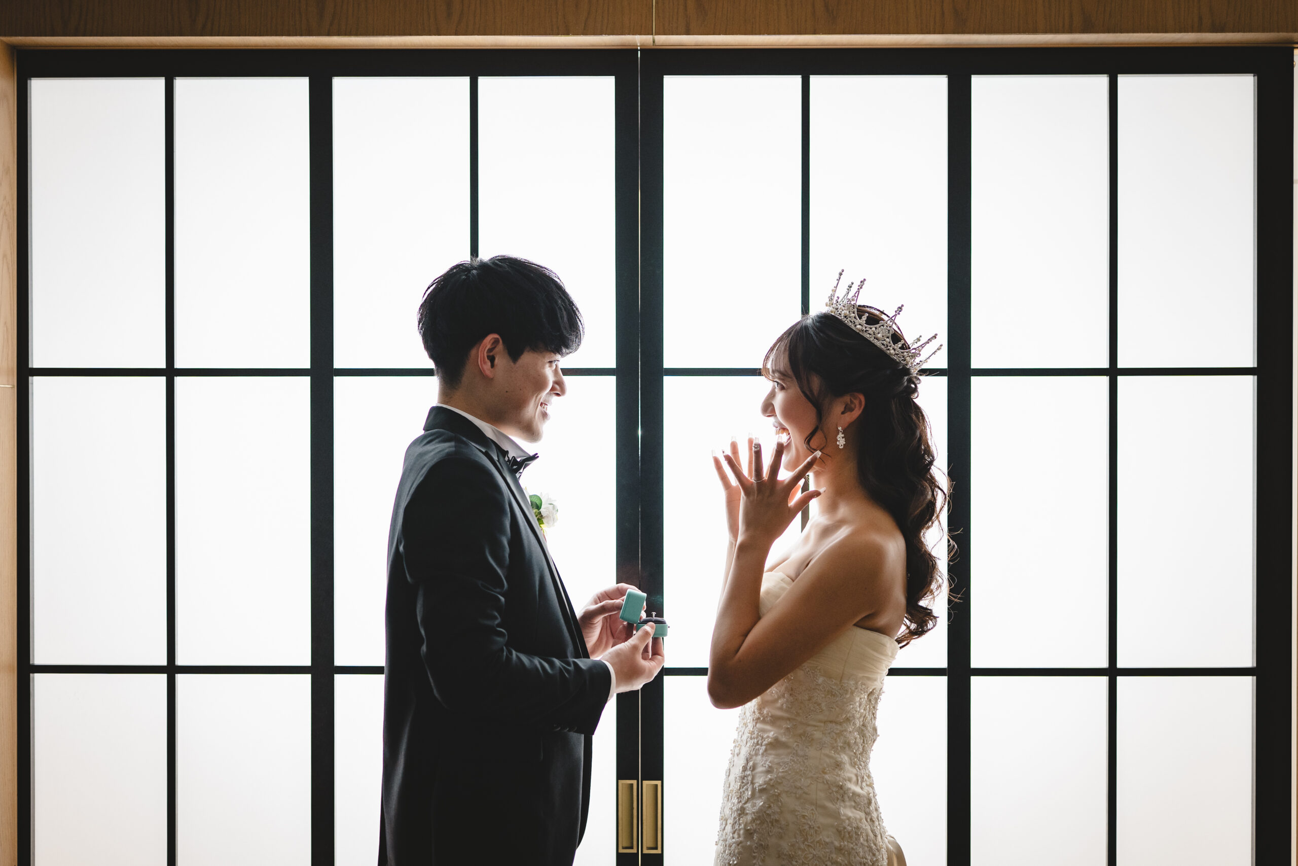 ティアラを着けた新婦にサプライズプロポーズをする新郎 障子窓を背景にした指輪演出