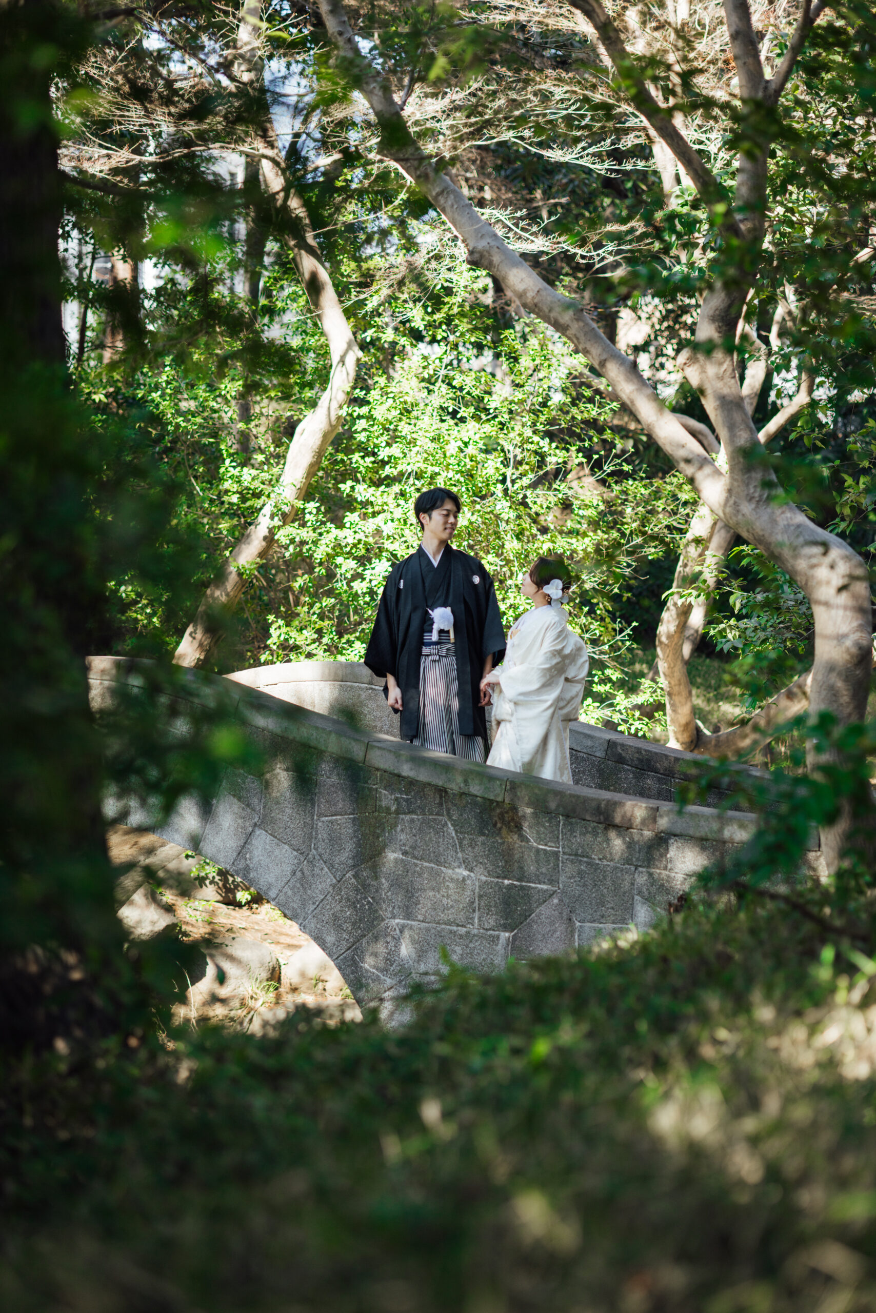 有栖川宮記念公園の小橋での和装前撮り実例、流れる水辺の小橋の上でふたりが寄り添う温かみのある一枚