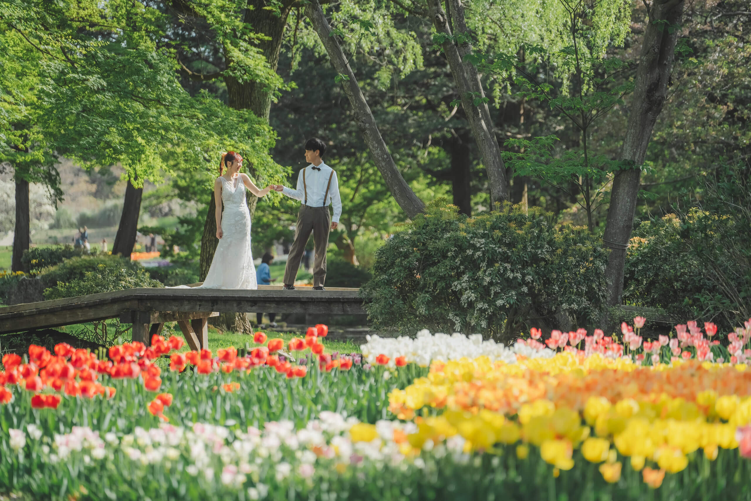 昭和記念公園の花の丘での洋装前撮り実例、一面に広がる花畑を背景にウェディングドレスが圧倒的な存在感で輝く感動的な一枚