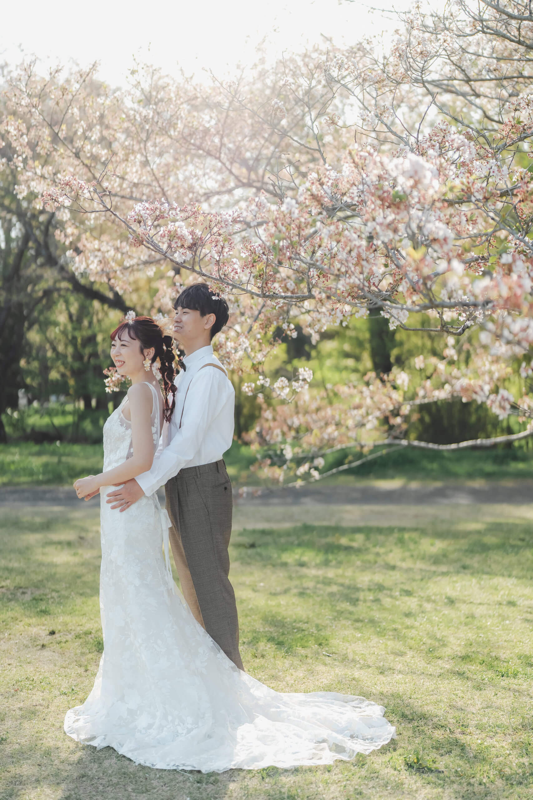 昭和記念公園の桜の園での洋装前撮り実例、満開の桜の下でウェディングドレスが春の光の中で輝く感動的な一枚