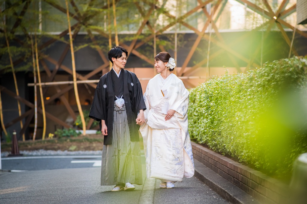 手をつないで街を歩く新郎新婦 黒紋付袴と白無垢の和装ロケーションフォト