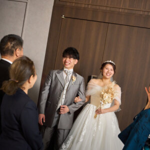 扉が開いて入場する新郎新婦を、着物姿の家族が笑顔で迎える瞬間。チャペルでの前撮りならではのセレモニーカット