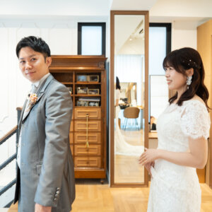 背を向けた新郎と、少し緊張した表情で立つレースのドレスの花嫁。ファーストミート直前を写した南青山のスタジオフォト