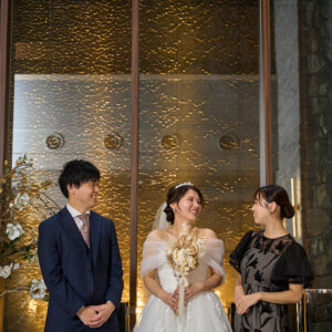 ブーケを持つ花嫁がゲストに囲まれて笑い合うチャペルでの一枚。和やかな雰囲気が伝わる結婚写真