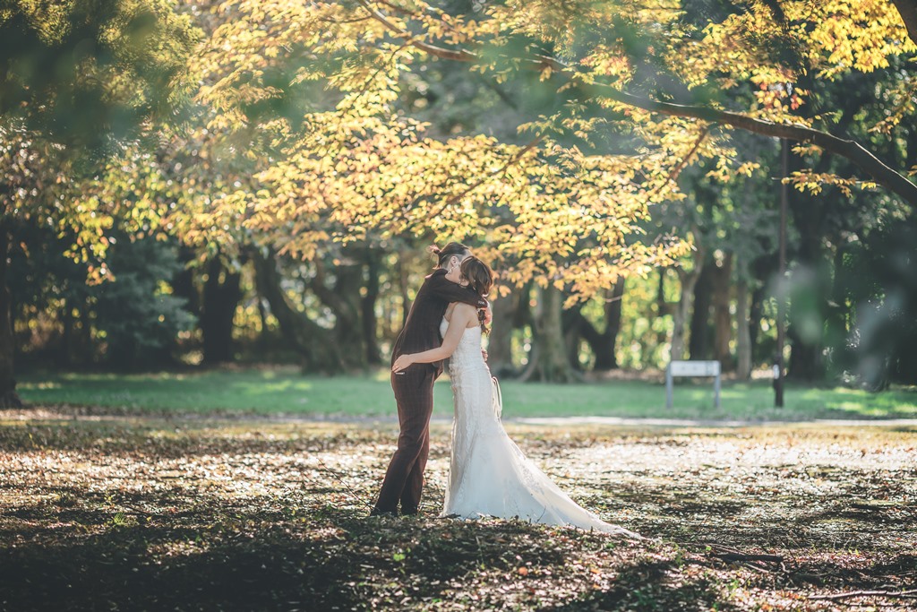砧公園の紅葉シーズンにウェディングドレスで撮影した前撮り実例写真、赤や橙に染まった木々が背景に広がる