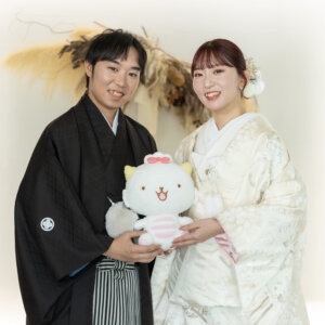白いネコのぬいぐるみを二人で抱いて笑う紋付袴の新郎と色打掛の花嫁。南青山のスタジオで撮るアイテムを使った和装前撮り